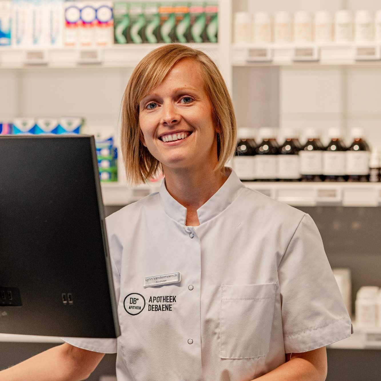 Lynn Vandermeersch achter de balie van Apotheek Debaene